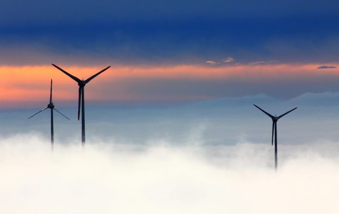 Wind turbines above low clouds